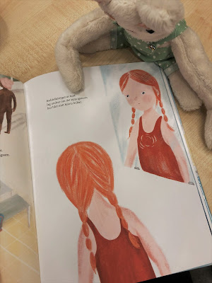 Ett uppslag med ett barn i baddräkt i boken.