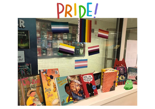 Prideflaggor och flera olika böcker står i ett fönster