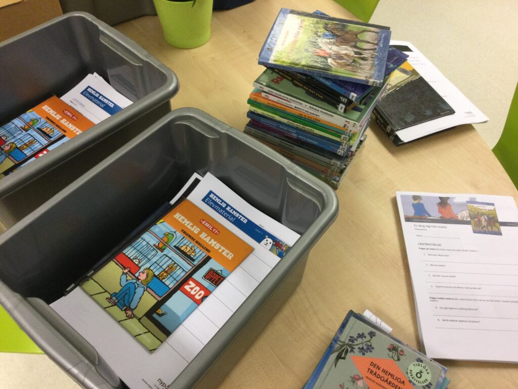 Två plastbackar som fylls med böcker från Nypon förlag inklusive elevmaterial